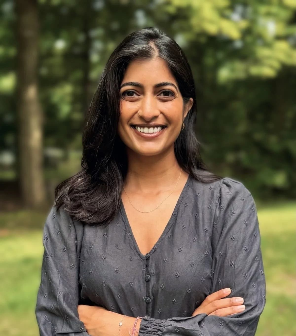 Vishakha Ramakrishnan smiling outdoors with arms crossed